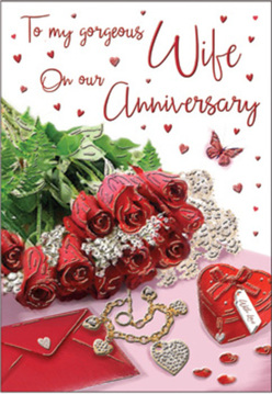 This anniversary card scene feels like a private love story captured on a table in Northolt, arranged with the same attention a florist brings to a special bouquet. At the centre, crimson red roses with lush, layered petals sit in a small cluster, their velvety surfaces almost glowing against soft, natural light. Fresh greenery curls around the blooms, adding a sense of movement and life, as though the flowers have just been placed down after delivery to a home near Northolt Station or the leafy paths around Lime Trees Park. Close by, a simple envelope rests with its flap slightly lifted, suggesting a heartfelt message about to be read. A petite heart-shaped box and a piece of jewellery lie alongside it, their smooth, reflective surfaces offering hints of gold or silver that play gently against the passionate reds of the flowers. The background is sprinkled with tiny red hearts and delicate shimmering accents, while a single butterfly motif drifts near the roses, bringing a touch of whimsy and hope, like the flutter of excitement on an anniversary morning. The whole composition is bathed in warm, flattering light that softens the edges and creates a calm, romantic atmosphere. The image conjures the familiar sensations of a fresh anniversary bouquet in Northolt-the clean scent of cut stems, the rustle of tissue paper, the quiet weight of a carefully chosen gift-coming together as a tender tribute to enduring love.