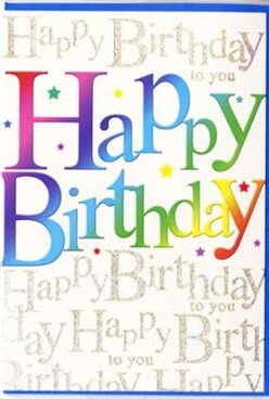 This birthday card glows with party spirit, as if it has captured the feeling of friends gathering in Northolt for a cheerful celebration. Dominating the front, the words "Happy Birthday" are written in generous, rounded letters that sweep confidently across the card. Each letter flows into the next through a soft gradient of colour: starting with rich sapphire and inky violet at one end, moving through teal, fresh leaf green, and goldenrod, and finally settling into warm amber and rose pink. The effect is like watching the sky change over Northolt's rooftops at dusk, one shade gently dissolving into another. The surface of the lettering appears velvety and smooth, with a subtle sheen, as though the ink has been carefully layered. Behind this rainbow phrase, the background is softly patterned with repeated lines of "Happy Birthday to you" written in delicate, looping golden script. These slender strokes glimmer under the light, suggesting fine metallic ink or a dusting of micro-glitter that catches your eye when the card is tilted, a bit like the sparkle of lights along Church Road in the evening. Scattered around the main words, tiny star-like dots and specks of colour drift across the design, giving the impression of confetti or fireworks just beginning to burst. Altogether, the card feels joyful but not overwhelming-perfect for pairing with a bright birthday bouquet delivered across Northolt, whether to a cosy home near the station or a surprise party gathering close to Northala Fields, where the colours of the card mirror the vibrancy of freshly arranged flowers.